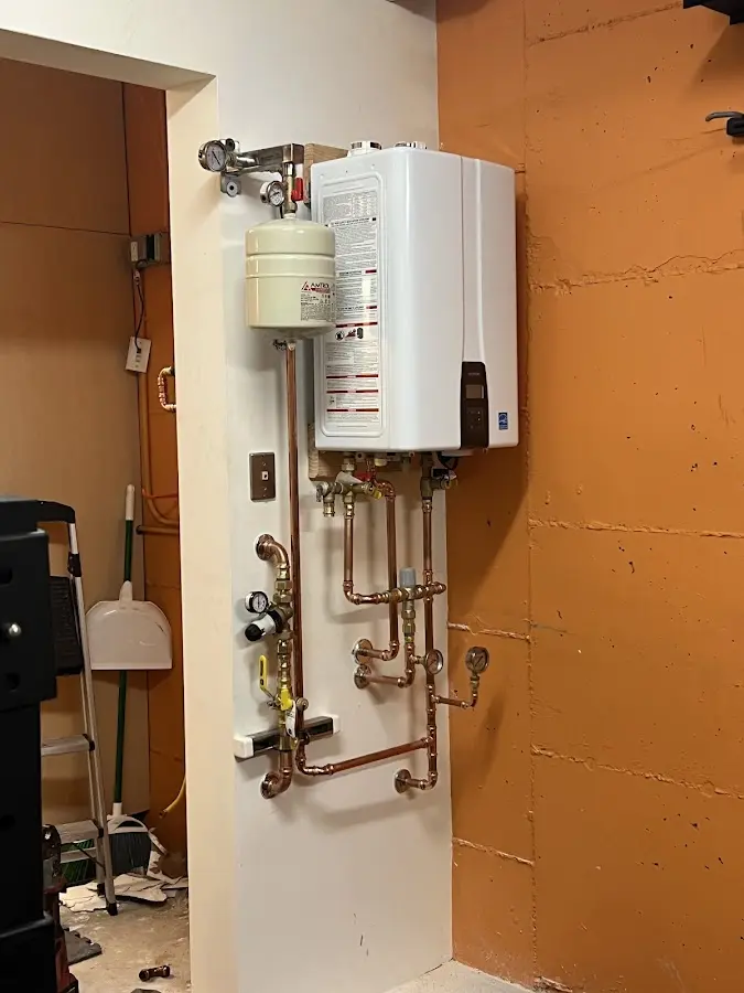 Plumbing technician inspecting water heater connections in Laureldale